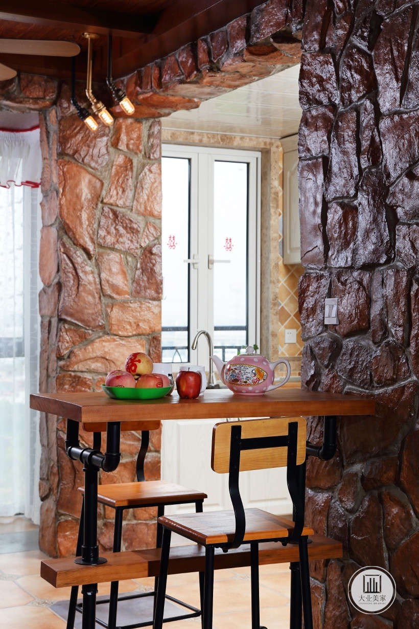 吧台，在厨房一角，厨房入口处黄色砖装饰墙柱，棕色木质桌面，营造了古朴的质感。