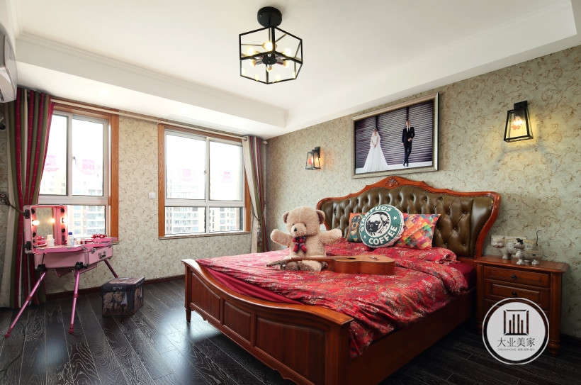 卧室，黑色木地板铺装地面，床头豆绿色壁纸，结婚画像和灯饰装饰背景墙面。深色床品和床头柜，两扇窗户增加了室内空间的通透性。