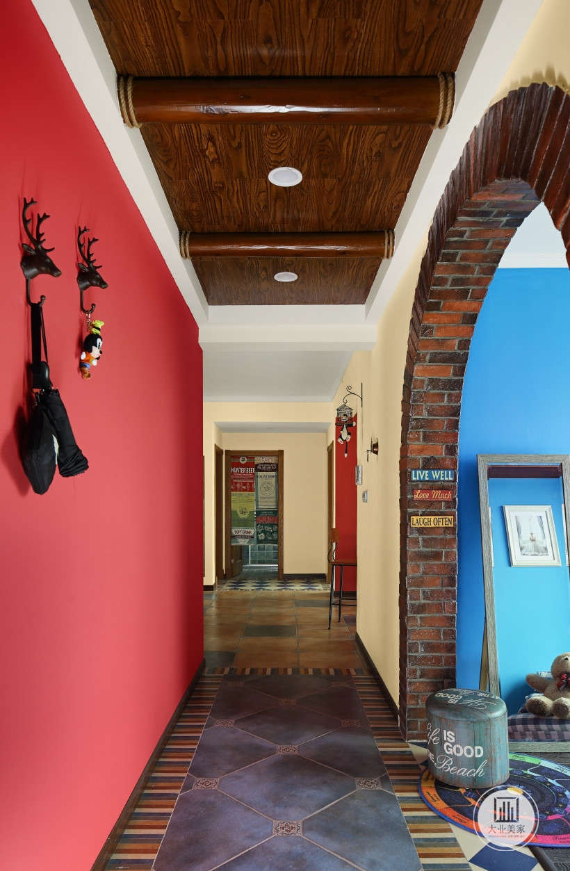 入户，墙面一侧红色乳胶漆面粉刷，休闲室蓝色乳胶漆面，色彩鲜艳，撞色搭配。入户挂钩设计方便摆放饰品和用品。