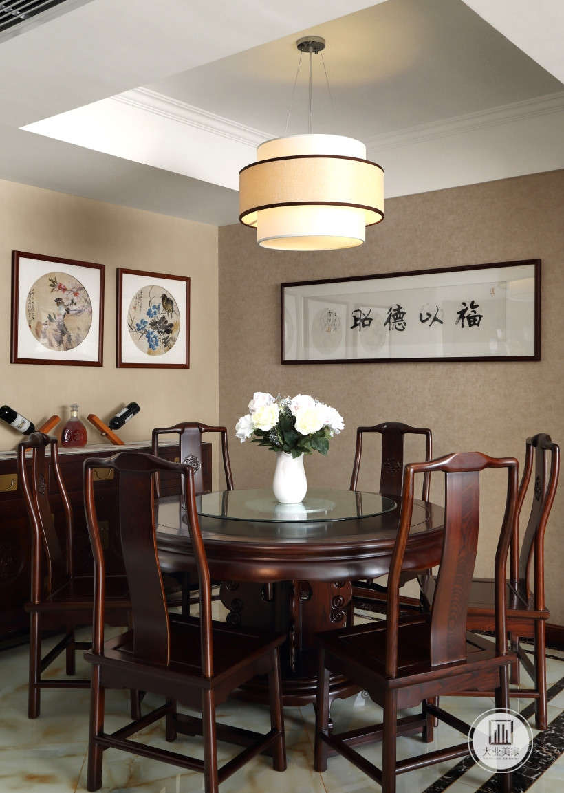餐厅，6人圆桌椅，浅黄色壁纸铺贴墙面搭配字画和风景挂画装饰墙面，深色木桌椅和储物柜摆放酒水。